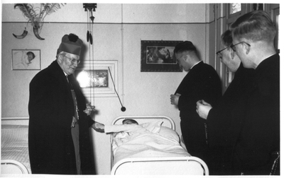 254151 Mgr. Lemmens in gesprek met een patient tijdens zijn bezoek aan huize Sint Joseph in Heerlen