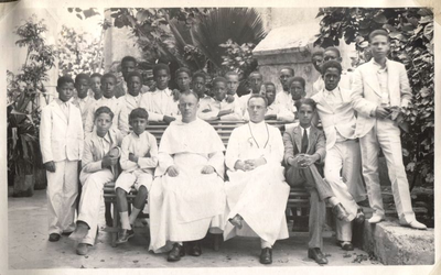 130569 Pater T.F.F.M. Bartel (links op de foto) en frater / directeur van de armenschool met schoolverlaters in de wijk ...