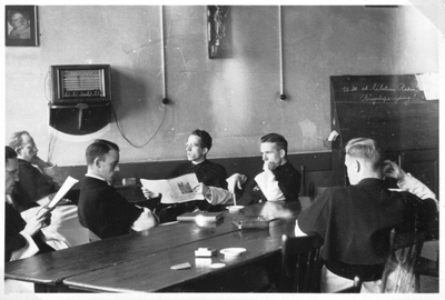 265129 Kruisheren rond de radio in de recreatiezaal van het klooster te St. Agatha