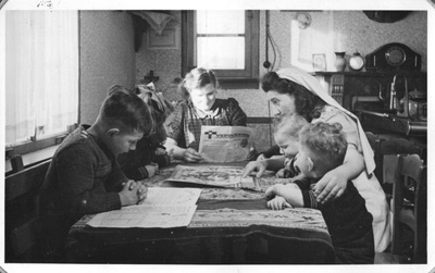 232093 Een gezinsverzorgster van de Catechisten leest/speelt met kinderen te Kloosterzande