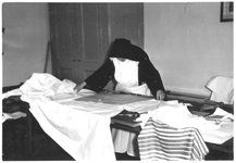 156087 Zuster Dominica in de textielkamer van het Clarissenklooster te Duivendrecht