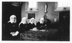 196024 Groepsfoto van de stichteressen in de recreatiezaal van huize Bethlehem te Nijmegen