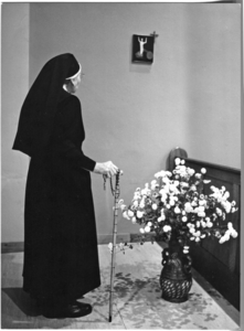 248431 Zuster met rozenkrans in contemplatief gebed bij een Kruiswegstatie in de kapel te Zundert