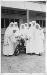 184135 Collega-zusters van de Voorzienigheid zijn blij met hun motorvoertuig te Paramaribo (Suriname)