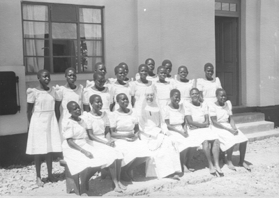 152049 Zuster Karoli met leerlingen van de kweekschool te Kakamega, Kenia