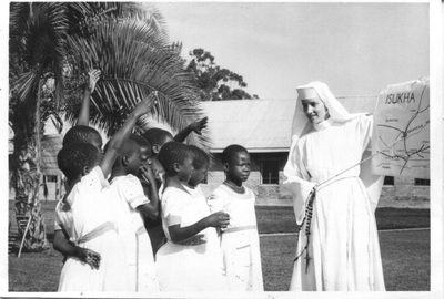 152055 Zuster Ludgardis geeft aardrijkskundeles aan de kinderen van Kakamega, Kenia