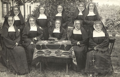 152386 Groepsfoto van de zustercommuniteit in de tuin van het klooster te Oudorp