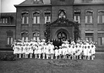 258250 Groepsfoto met zusters en vele bruidsmeisjes voor het klooster te Kloosterburen