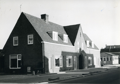  Een blok van 4 woningen met in het midden een poort daarboven het jaartal 1924, rechts daarvan een houten noodgebouw.