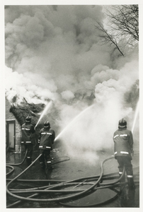 3777 - Blussende brandweer bij een brandende woning