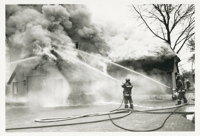 3778 - Blussende brandweer bij een brandende woning