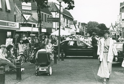 13253 - centrum Nunspeet; drukte op straat; meisje op bank, wit jack: Petra Verbeek