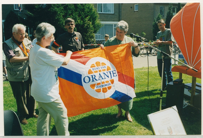 11040 - Ter gelegenheid van 5 mei viering 2000, 55 jaar bevrijding. Twee dames tonen nabij de Kanovijver de vlag van de ...