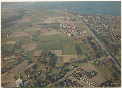 13910 - Luchtfoto van een gedeelte van het buitengebied van Ermelo en woonwijkten van Harderwijk. Op de achtergrond het ...