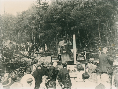 16728 - Op de voorgrond mensen die kijken naar een Canadese bulldozer met kenteken: N944-1236.SE 185. Er staat een bord ...