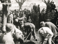 16779 - Zeven NSB-ers zijn in verband met herstelwerkzaamheden aan het graven. Een grote groep Harderwijkers kijkt toe