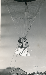 16939 - Een luchtballon stijgt op. Hij zit nog met twee lijnen aan de aarde vast.Er staan drie mannen in. De rechter ...