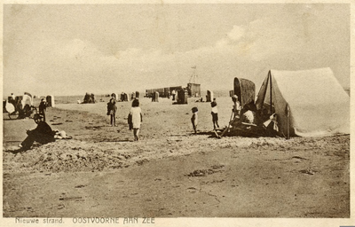 PB4955 Een tent, strandstoel en badkoetsjes op het strand, ca. 1930