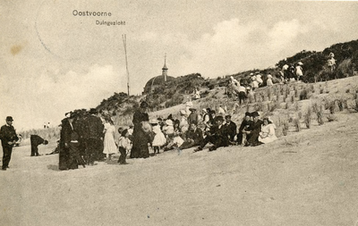 PB5276 Een groep kinderen en volwassenen zitten tegen de duinen nabij Koepel Zeeburg, ca. 1916