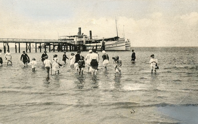 PB5460 Badgasten staan pootje te baden in zee. De Maasnymph ligt aangemeerd aan het steiger, 1914