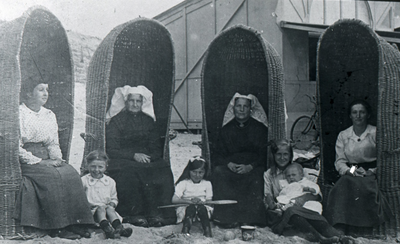 DIA30236 Een viertal vrouwen zit in hoge rieten strandstoelen; ca. 1935