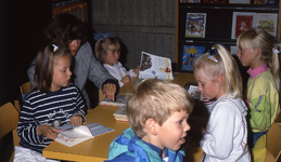 DIA42582 De Openbare Bibliotheek van Spijkenisse: kinderen bladeren door boeken; Augustus 1990