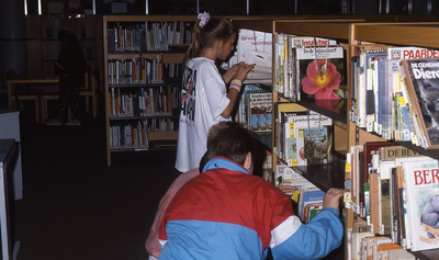 DIA42583 De Openbare Bibliotheek van Spijkenisse: kinderen bladeren door boeken; Augustus 1990