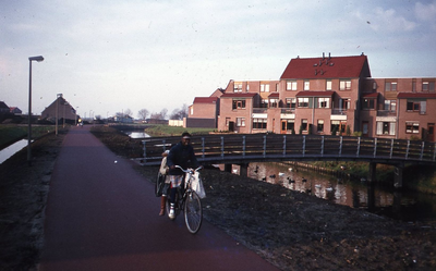 DIA44157 Een fietser rijdt over de Meeldijk, ter hoogte van de brug naar de Saffraandonk; Februari 1982