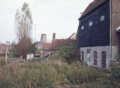 DIA44424 Achterzijde van woningen aan het Noordeinde, op de achtergrond het Gemaal de Leeuw van Putten en de molen ...