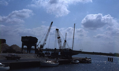 DIA69414 De zand en grindhandel bij de haven langs het Spui; ca. 1982