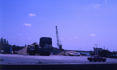 DIA69474 De zand en grindhandel bij de haven langs het Spui; ca. 1982