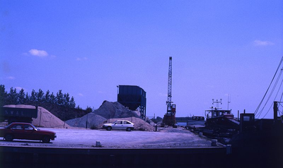 DIA69475 De zand en grindhandel bij de haven langs het Spui; ca. 1982