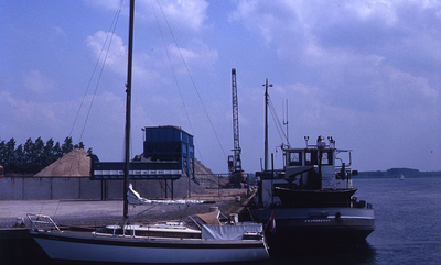 DIA69477 De zand en grindhandel bij de haven langs het Spui; ca. 1982