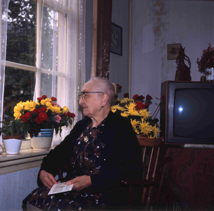 DIA_GF_1109 Een oudere vrouw (lid van de katholieke kerk) in haar huiskamer; ca. 1967
