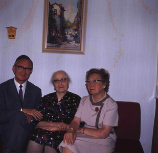 DIA_GF_1115 Een oudere vrouw (lid van de katholieke kerk) in haar huiskamer, met de pastoor; ca. 1967