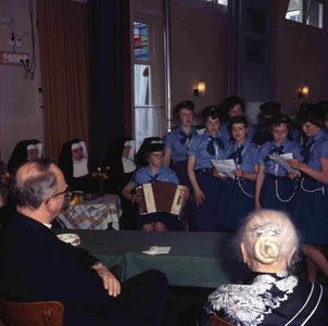 DIA_GF_1131 Een afscheidsreceptie van de pastoor (?). Een kinderkoor treedt op; ca. 1967