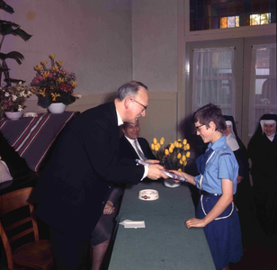 DIA_GF_1132 Een afscheidsreceptie van de pastoor (?). Een kinderkoor treedt op; ca. 1967