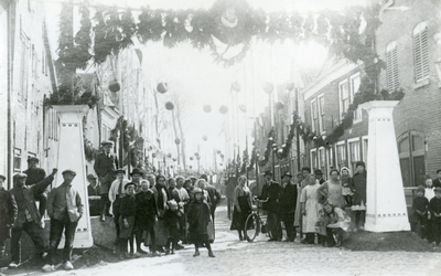 BR_1APRIL_1922_044 Kijkje in de Kaaistraat, waar een fraai versierde erepoort staat; 1 april 1922