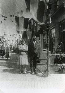 BR_1APRIL_1922_053 Oma Verhoef voor haar met vlaggen versierde winkel; 1 april 1922
