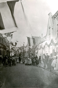 BR_NIEUWSTRAAT_062 Kijkje in de versierde Nieuwstraat, met groepen kinderen en bewoners; ca. 1913