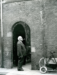 BR_NOBELSTRAAT_142 De schoenhandelaar H.J.B. Verbrugge staat voor de katholieke kerk; ca. 1961