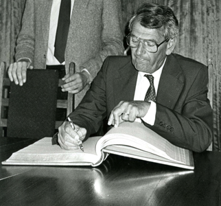 BR_PERS_RONDE_025 Burgemeester C.J. de Ronde tekent een dik boek; ca. 1985