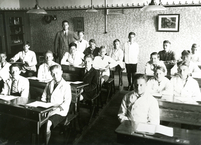 BR_SCHOLEN_AMBACHTSSCHOOL_006 Theorielokaal in de Ambachtsschool met de onderwijzer de heer J.L. van den Brink; 1931