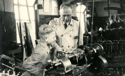BR_SCHOLEN_AMBACHTSSCHOOL_050 Onderwijzer Gelms met een leerling in het lokaal en werkplaats van de smederij; ca. 1937