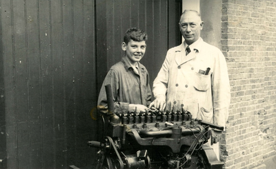 BR_SCHOLEN_AMBACHTSSCHOOL_055 Onderwijzer Gelms geeft een leerling les in het onderhoud van motoren; ca. 1937