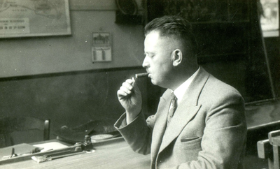 BR_SCHOLEN_OLS_006 Hoofdonderwijzer C. Schipper van de Openbare Lagere School steekt een sigaar op; 1936