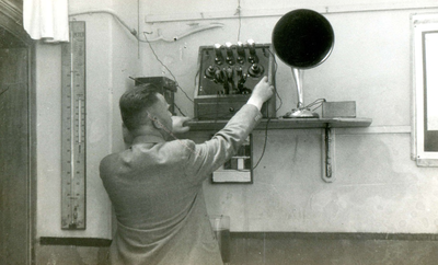 BR_SCHOLEN_OLS_007 Hoofdonderwijzer C. Schipper van de Openbare Lagere School bedient een radio; 1936