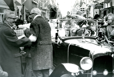BR_SINTERKLAAS_1969_003 Onder grote belangstelling wordt Sinterklaas in een auto door de Voorstraat gereden; november 1969