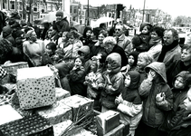 BR_SINTERKLAAS_1990_009 De intocht van Sinterklaas in Brielle. Kinderen en ouders kijken naar de wagen vol pakjes; 17 ...