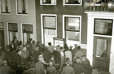BR_VOORSTRAAT_153 Een menigte mensen bekijkt bij het kantoor van de Nieuwe Brielse Courant de uitslag van de ...